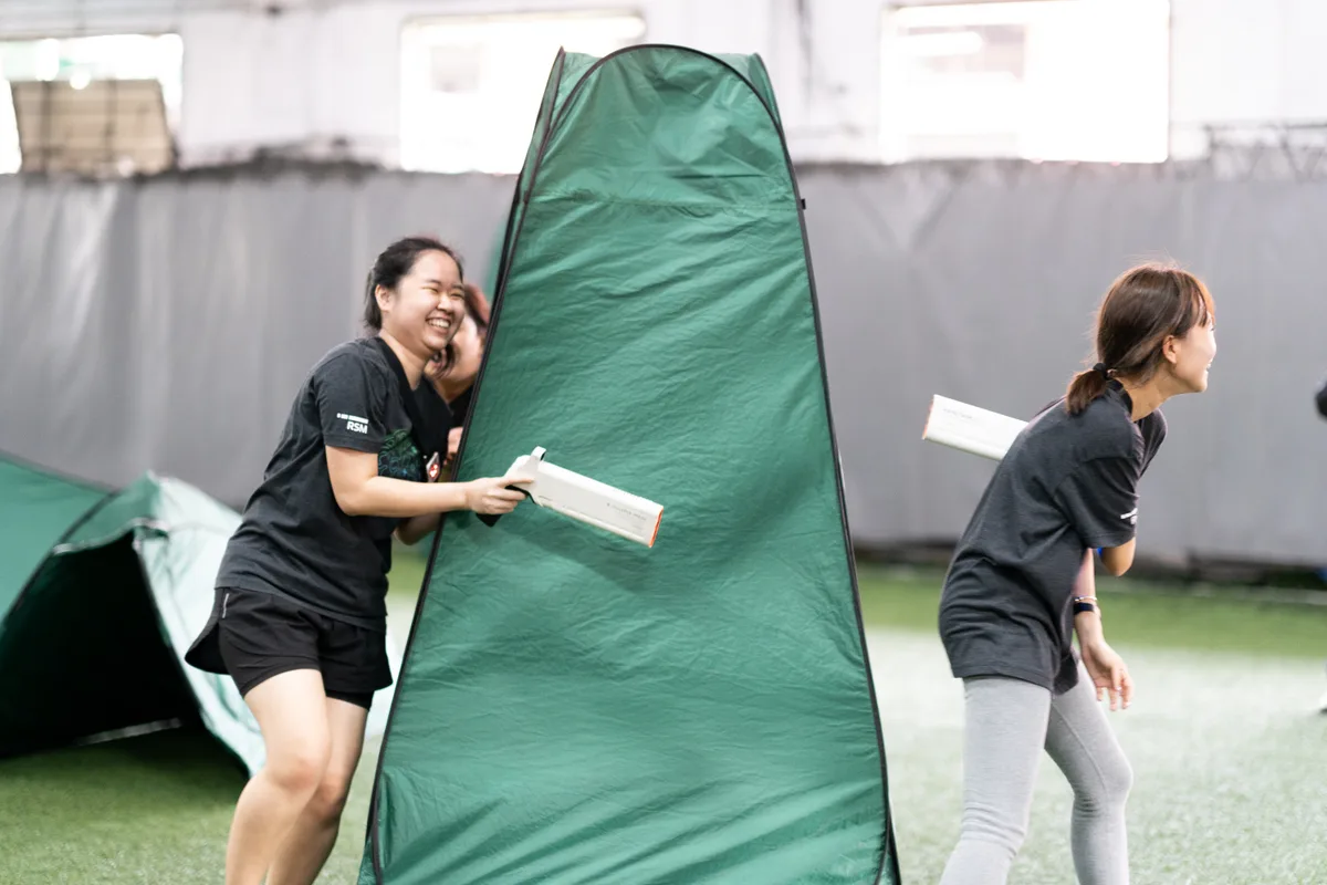 Participants playing Laser Tag indoors during a Cohesion team building activity